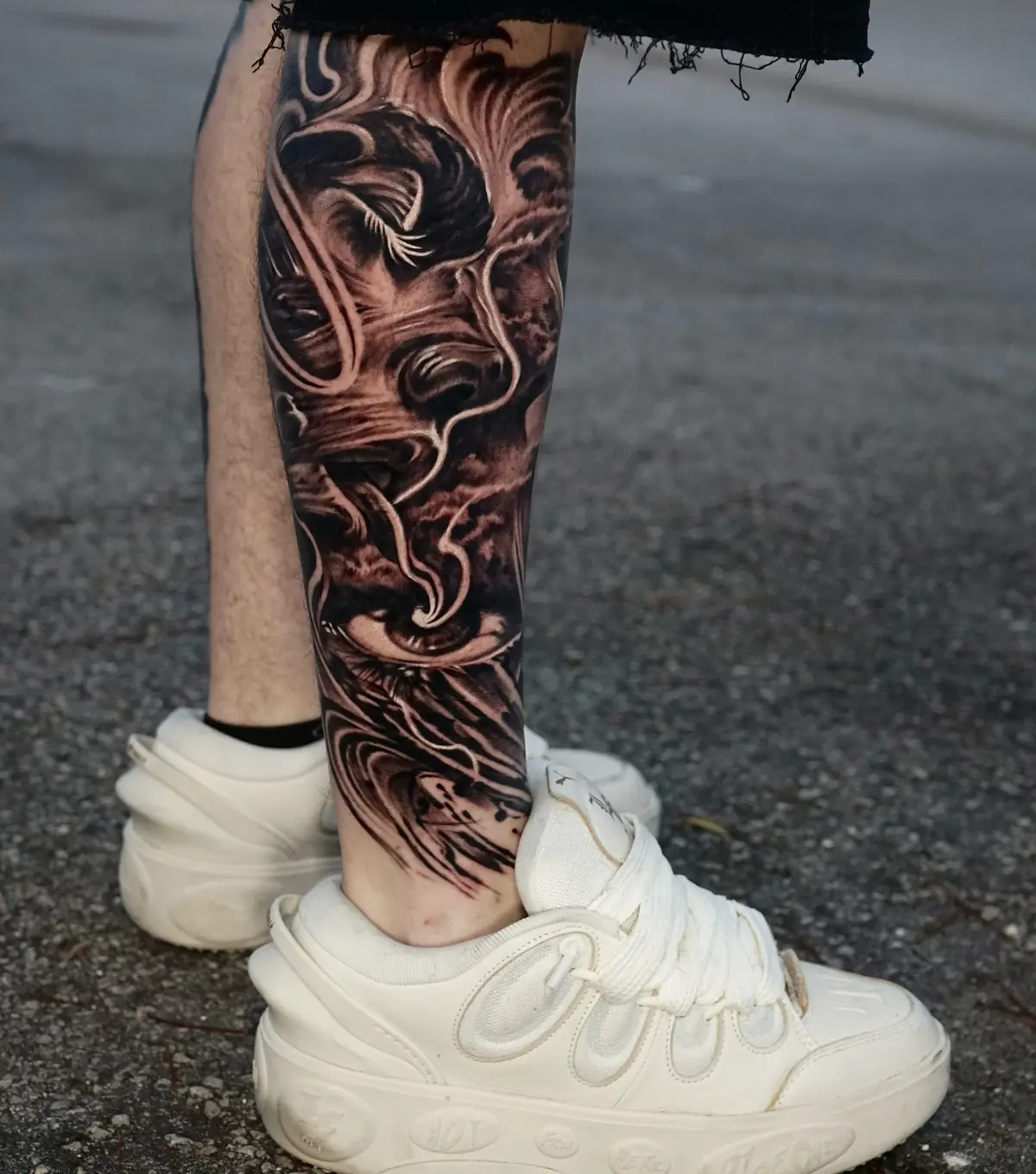 Black and grey koi fish leg sleeve with a dramatic eye and flowing wave textures