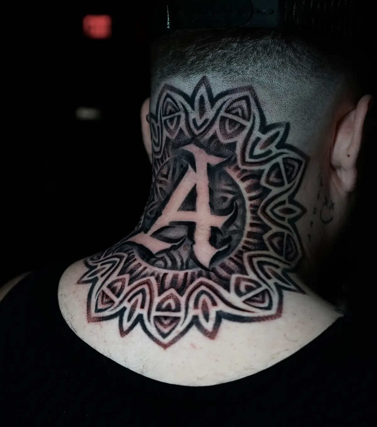 Bold Celtic knot tattoo extending across the neck and upper back