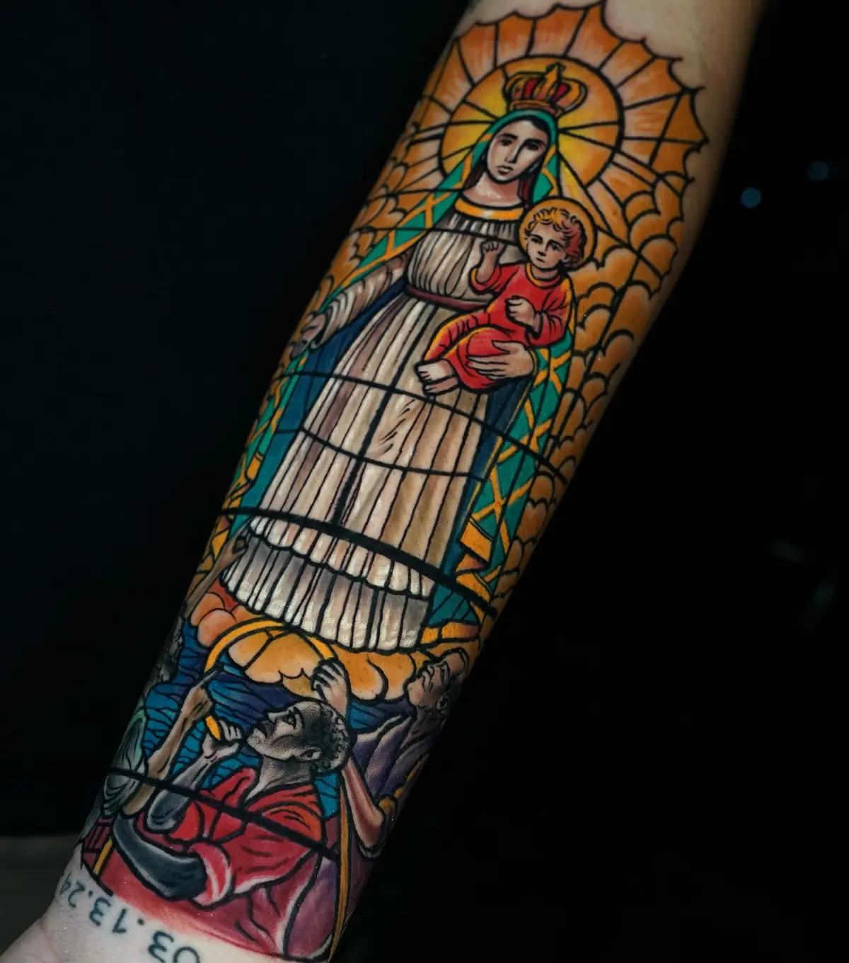 Traditional stained-glass style tattoo of the Virgin Mary and child above kneeling figures