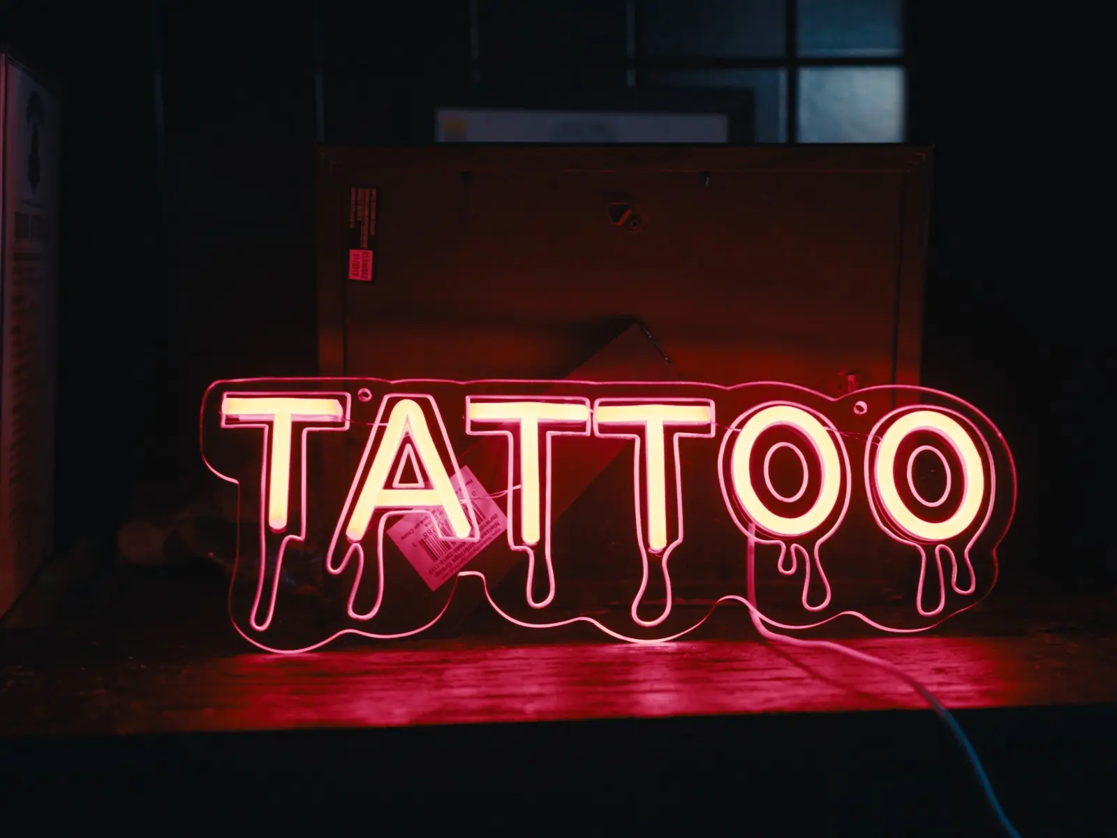Red tattoo neon sign inside the House en Llamas studio